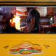 A food truck window opening up to the kitchen with a flame coming from its stove